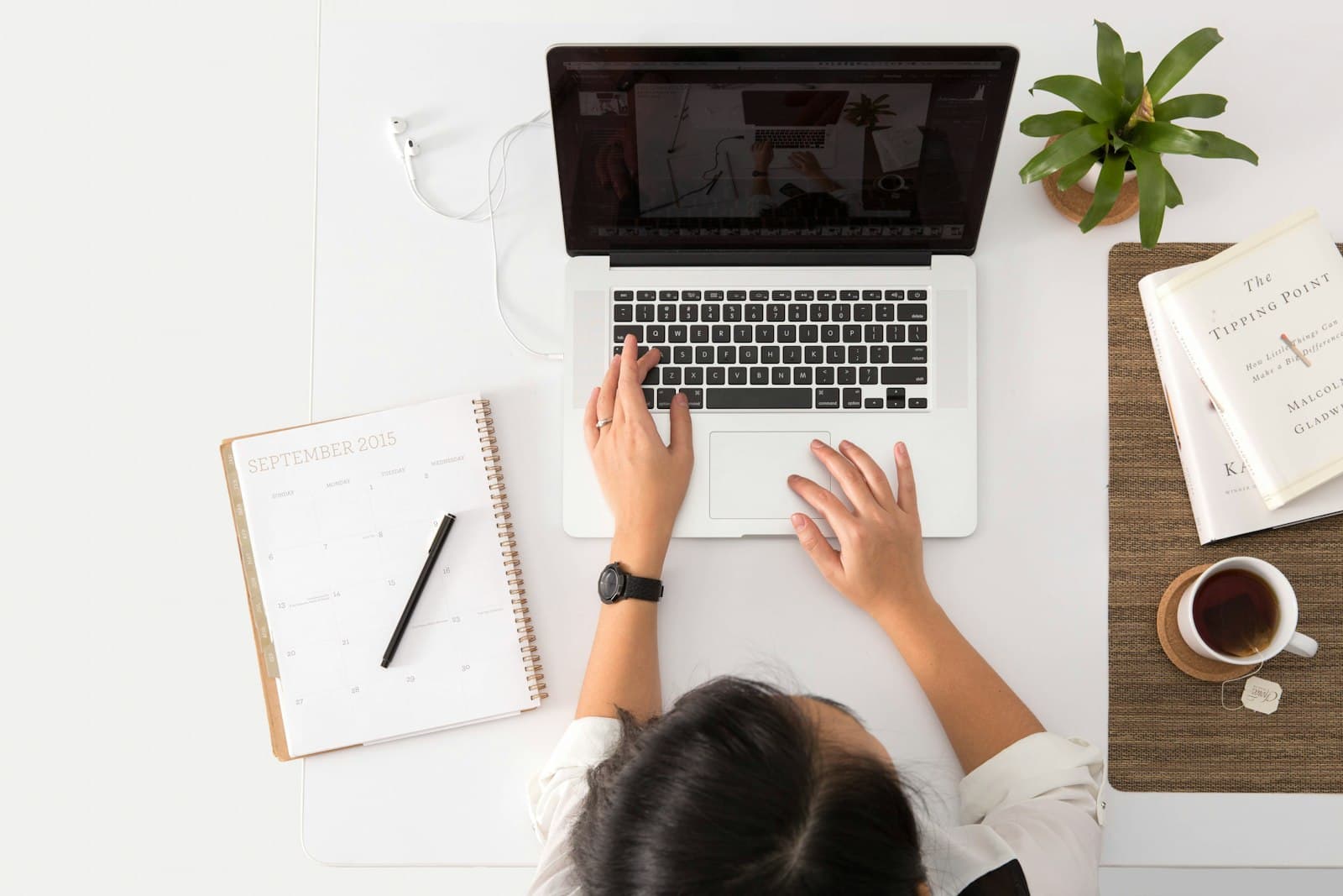 Overhead view of a laptop, planner, and coffee set up for a virtual coaching session